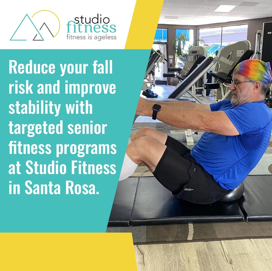 An older man wearing a colorful headband exercises on a mat in a gym next to a sign promoting senior fitness programs at Studio Fitness in Santa Rosa.