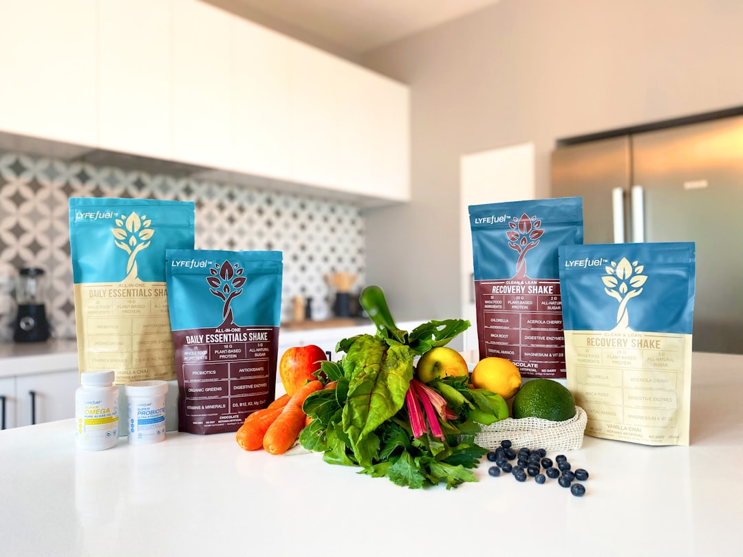 A kitchen counter with supplements, protein shake bags, fresh vegetables, leafy greens, fruits, and a blender in the background—perfect for seniors interested in customized nutrition plans to support healthy living. A kitchen counter with supplements, protein shake bags, fresh vegetables, leafy greens, fruits, and a blender in the background—perfect for seniors interested in customized nutrition plans to support healthy living.